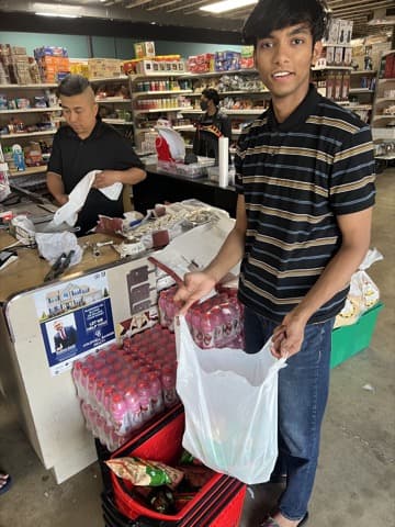 Customer holding grocery bags inside a neighborhood store