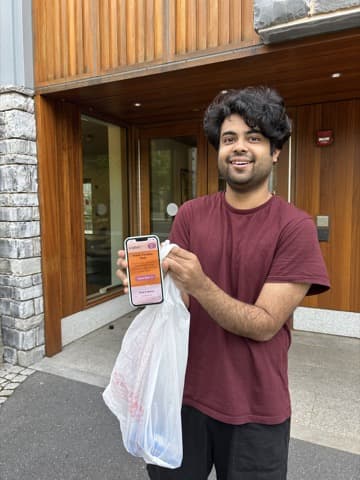 Customer showing the Sarva app with a grocery delivery bag